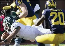 ?? CARLOS OSORIO — THE ASSOCIATED PRESS ?? Michigan State running back Connor Heyward, left, crosses the goal line past Michigan’s Brad Hawkins for a touchdown in Saturday’s win.