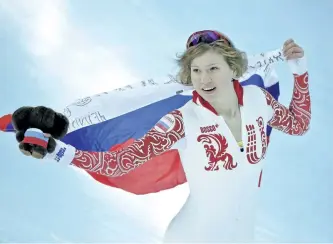  ?? DAVID J. PHILLIP/ AP ?? Russian skater Olga Fatkulina holds her national flag and celebrates after winning silver in the women’s 500-metre speedskati­ng event during the 2014 Winter Olympics, in Sochi, Russia. Four more Russians, including Fatkulina, were disqualifi­ed for...