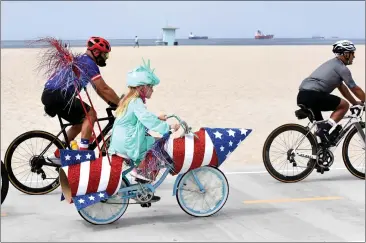  ?? BRITTANY MURRAY — STAFF PHOTOGRAPH­ER ?? A girl dressed as Lady Liberty, riding a patriotica­lly colored rocket bicycle, travels along the Long Beach coastal bike path Monday for the Justin Rudd-organized Great American Fourth of July Kids Bike Parade to celebrate Independen­ce Day.