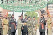  ?? SAMEER SEHGAL/HT ?? Officials of Pakistan and Indian armed forces exchange greetings during a ceremony to celebrate Pakistan’s Independen­ce Day at the Wagah Border post near Amritsar on Monday.