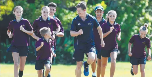  ?? Picture: ADAM HEAD ?? Commonweal­th Games athlete and Varsity College teacher Murray Goodwin back at school with some kids including Austin Foat, 8, (front).