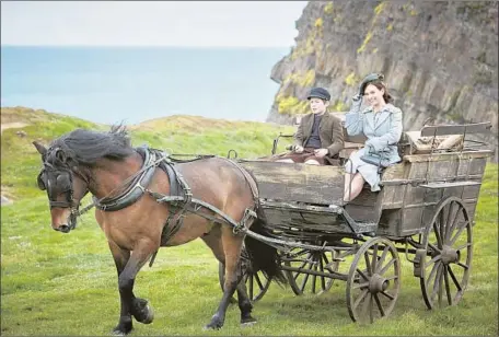  ?? Photograph­s by Kerry Brown Netf lix ?? LILY JAMES, shown with Kit Connor, portrays a London writer in the period film “The Guernsey Literary and Potato Peel Pie Society.”