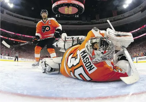  ?? PHOTOS: ELSA / GETTY IMAGES ?? Goalie Steve Mason and the Philadelph­ia Flyers had a rough night in Game 3 of their playoff series against the Capitals. Several fans were disgusted, too — throwing giveaway bracelets onto the ice.