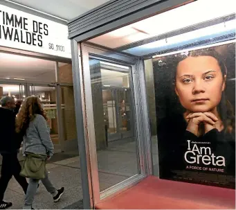  ?? I Am GETTY IMAGES ?? Moviegoers arrive at Kino Internatio­nal movie theatre as a poster advertises the film Greta, about the Swedish environmen­tal activist Greta Thunberg, on November 1, 2020 in Berlin.