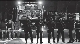  ?? Policisté střeží autobus fotbalové Borussie Dortmund poškozený výbuchem. FOTO ČTK/ AP ?? Po útoku.