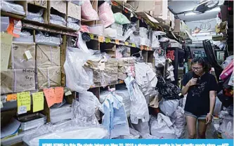  ??  ?? HONG KONG: In this file photo taken on May 20, 2018 a shop-owner walks in her plastic goods store. —AFP