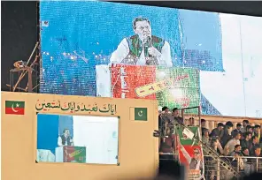  ?? ?? Imran Khan speaks from behind a screen to address supporters at a packed rally in Lahore yesterday