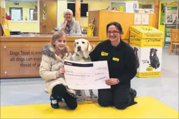  ??  ?? Cora Hannaford presents the Dogs Trust with £250, which she raised by asking friends to donate cash for her birthday rather than presents