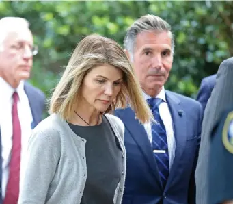  ?? STUART CAHILL / HERALD STAFF FILE ?? ‘HAH!’: Actress Lori Loughlin and husband Mossimo Giannulli, seen leaving federal court in the Seaport last summer, are captured in phone transcript­s filed by the feds in the ‘Varsity Blues’ case.