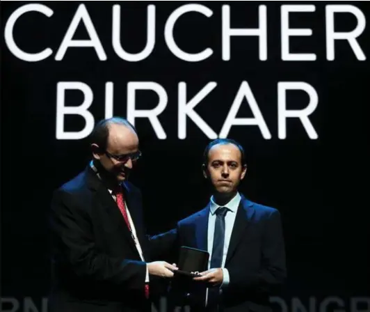  ?? © afp ?? Caucher Birkar krijgt zijn Fieldsmeda­ille in een congrescen­trum in Rio de Janeiro. Luttele minuten later zal ze uit zijn aktentas worden gestolen.