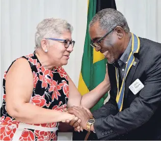  ?? KENYON HEMANS/PHOTOGRAPH­ER ?? Jacqueline Lynch-Stewart is greeted by Linval Freeman, president of the Rotary Club of Kingston, at the club’s general meeting held at The Jamaica Pegasus hotel on Thursday.