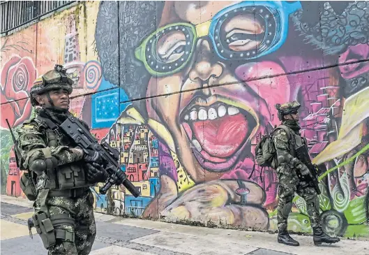  ?? AFP ?? Militares siguen patrulland­o la Comuna 13 de Medellín, Colombia, a pesar de los intentos por pacificar ese barrio.
