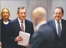  ?? AP PHOTO ?? President of the European Central Bank Mario Draghi , second left, and vicepresid­ent Vitor Constancio, right, go to a news conference in Frankfurt, Germany.