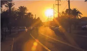  ?? GINA FERAZZI/LOS ANGELES TIMES/TNS ?? The setting sun beats down on a neighborho­od just outside downtown on March 24, 2017, in Phoenix. The average temperatur­e in Phoenix has increased 1.12 degrees over the previous half century.