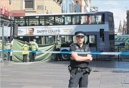  ??  ?? Officers guard the scene of the bus accident on Queen Street in Glasgow yesterday which left two hurtPictur­e: Robert Perry