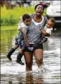  ?? ASSOCIATED PRESS ?? Terrian Jones reacts as she feels something moving in the water while carrying Drew and Chance Furlough to their mother in New Orleans on Wednesday.