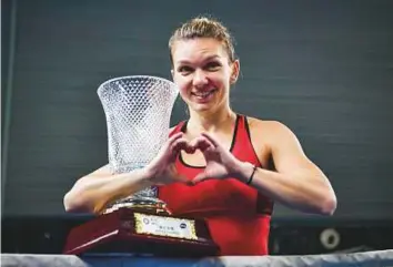 ?? AFP ?? Simona Halep of Romania celebrates with the trophy after her victory against Katerina Siniakova of the Czech Republic in the WTA Shenzhen Open in Guangdong province, China.