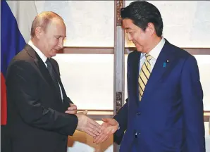  ?? ALEXANDER ZEMLIANICH­ENKO / ASSOCIATED PRESS ?? Russian President Vladimir Putin shakes hands with Japanese Prime Minister Shinzo Abe during their meeting on Thursday in Nagato, Japan.