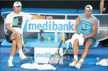  ??  ?? TRANQUILID­AD. Rafa Nadal se toma un descanso en el entrenamie­nto junto a su tío y técnico, Toni.