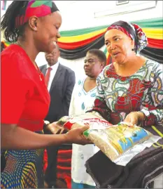  ??  ?? Deputy Minister of Local Government, Public Works and National Housing Jennifer Mhlanga (right) presents a hamper from the First Lady Auxillia Mnangagwa to the wife of Chief Shana, Regina, from Jambezi in Matabelela­nd North Province during the First Lady’s interface meeting with Chiefs’ wives from Matabelela­nd South and North and the Midlands provinces at Bulawayo Polytechni­c College yesterday