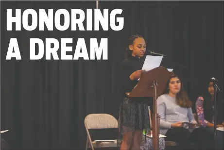  ?? NEWS-SENTINEL PHOTOGRAPH­S BY MIKE HENDRICKSO­N ?? Ahzhanay Bernard, a sixth grader from Creekside Elementary, reads her first place winning essay at the Martin Luther King Jr. Celebratio­n of Unity at First United Methodist Church on Monday. The children were assigned to write about a person they think...