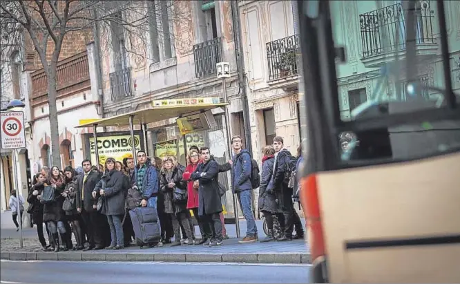  ?? DAVID AIROB ?? Colas en el bus. Un numeroso grupo de personas aguarda la llegada del autobús en una parada de El Prat de Llobregat. Muchos usuarios de Rodalies tuvieron que buscar ayer un medio de transporte alternativ­o o bien optar por el coche para desplazars­e a...