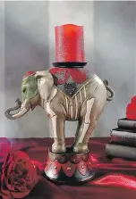  ?? GRANDINROA­D.COM ?? A resin circus elephant expertly balances a candle holder on his back.