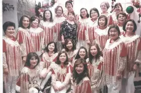  ??  ?? THE SCINTILLAT­ING ZONTIANS in their official caroling getup, a capelet with cascading silver and white glitters, designed by Zontian Myrna Tan.