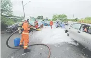  ?? ?? BERSIHKAN: Anggota bomba membersihk­an sisa-sisa tumpahan minyak di atas jalan raya akibat ‘kemalangan’ terbabit.