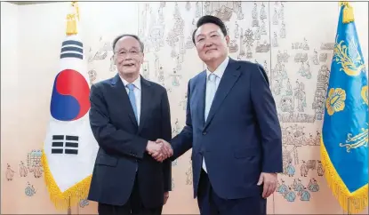  ?? LI TAO / XINHUA ?? Yoon Suk-yeol (right), new president of the Republic of Korea, meets Chinese Vice-President Wang Qishan in Seoul on May 10. Wang attended Yoon’s inaugurati­on ceremony.