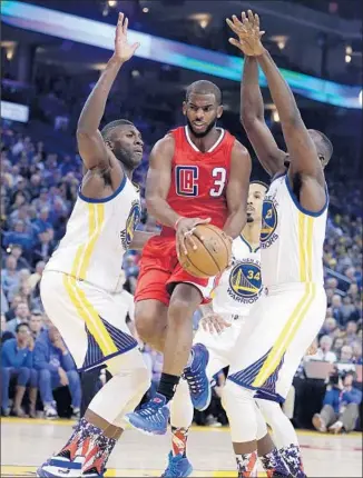  ?? Ben Margot Associated Press ?? CHRIS PAUL of the Clippers is in the middle of a trio of Warriors — Festus Ezeli, left, Shaun Livingston (34) and Draymond Green. Paul scored 20 of his 24 points in the first half.