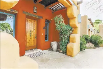  ??  ?? The adobe-style home offers Sante Fe style-living.