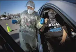  ?? Irfan Khan Los Angeles Times ?? TRAVEL NURSE Reshicka Upshaw, 40, of Cincinnati gets a thank-you bump from Alfred Gutierrez, 70, after he received his Pfizer vaccinatio­n in Ontario.