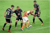  ??  ?? Wellington Phoenix defenders surround Brisbane Roar striker Massimo Maccarone on Saturday night.