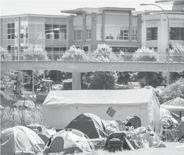  ?? TC FILE ?? The tent city at Regina Park in Saanich, with Uptown shopping centre in the background. Communitie­s need to work together with tent-city residents to find solutions to homelessne­ss, Bernie Pauly and Katrina Barber write.