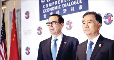  ?? BRENDAN SMIALOWSKI/AFP ?? US Treasury Secretary Steven Mnuchin (left) and Chinese Vice Premier Wang Yang pose for a photo before an opening session at the US and China Economic Dialogue at the US Department of Treasury in Washington, DC, on July 19, 2017.