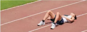  ?? Photo: Elson Li ?? An exhausted young man lies on the track at Hammer Hill Road Sports Ground yesterday.