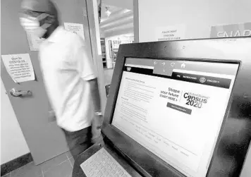  ?? JOE BURBANK/ORLANDO SENTINEL ?? A worker passes by the U.S. Census Bureau computer kiosk Wednesday at the Maxey Community Center in Winter Garden.