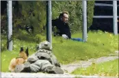  ?? NILS MEILVANG — RITZAU SCANPIX ?? A police officer watches Peter Madsen as he sits on the side of a road after being apprehende­d following a failed escape attempt in Albertslun­d, Denmark, on Tuesday.