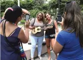  ?? AP ?? Fans who spotted Venezuelan singer Reymar Perdomo at a park in Lima, Peru, pose for photos with her.