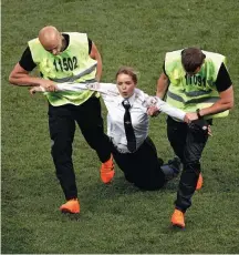  ?? ADRIAN DENNIS/AFP ?? Protesto. Ativista é retirada do gramado após invasão