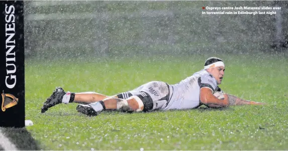  ??  ?? > Ospreys centre Josh Matavesi slides over in torrential rain in Edinburgh last night