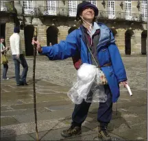  ?? (Rick Steves’ Europe/Rick Steves) ?? A jubilant pilgrim on Spain’s Camino de Santiago marks the end of her journey in front of the cathedral in Santiago de Compostela.