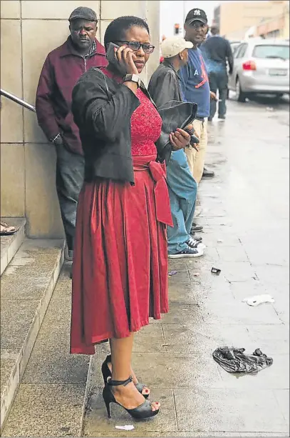  ?? Picture: ZWANGA MUKHUTHU ?? NO CHANGE IN BAIL: Murder accused Bulelwa Ndudula talks on the phone as she leaves the East London Magistrate's Court yesterday