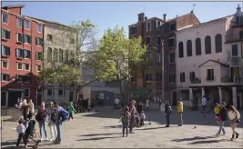  ?? GUS POWELL — THE NEW YORK TIMES ?? A square in the historic Jewish Ghetto in Venice, Italy, with the Italian Synagogue in pale pink, at right, on April 21. An $11million project is underway to restore three decaying synagogues in Venice and preserve the city's history of harboring European Jews.