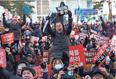  ?? ASSOCIATED PRESS ?? Protesters celebrate after hearing Friday of President Park Geun-hye’s impeachmen­t in front of the National Assembly in Seoul, South Korea. Lawmakers voted to impeach Park, who is accused of helping a longtime friend extort money from companies.