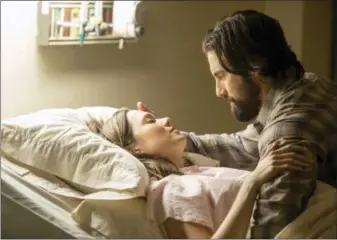  ?? RON BATZDORFF — NBC VIA AP ?? Mandy Moore, left, and Milo Ventimigli­a in a scene from “This Is Us.” The season finale for the popular timetwisti­ng family drama will air Tuesday at 9 p.m. EST on NBC.