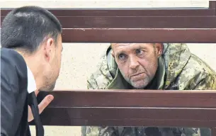  ?? THE ASSOCIATED PRESS ?? One of the captured Ukrainian sailors speaks with his lawyer in a courtroom in Crimea Tuesday.