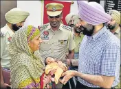  ?? SAMEER SEHGAL/HT ?? Commission­er of police Sukhchain Singh Gill (right) handing over the child to his grandmothe­r in Amritsar.