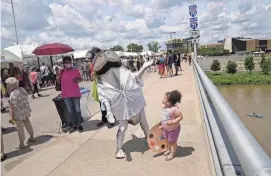  ?? ?? Lucy Dabbs, 3, of Evansville, Ind., stops for a picture with the Columbus Arts Festival shark mascot.